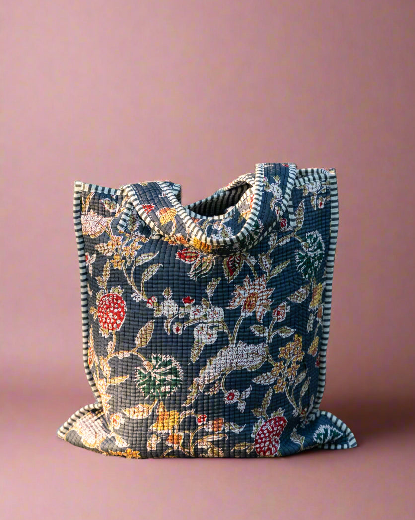 Floral-patterned bag on a stone surface with a stone wall background