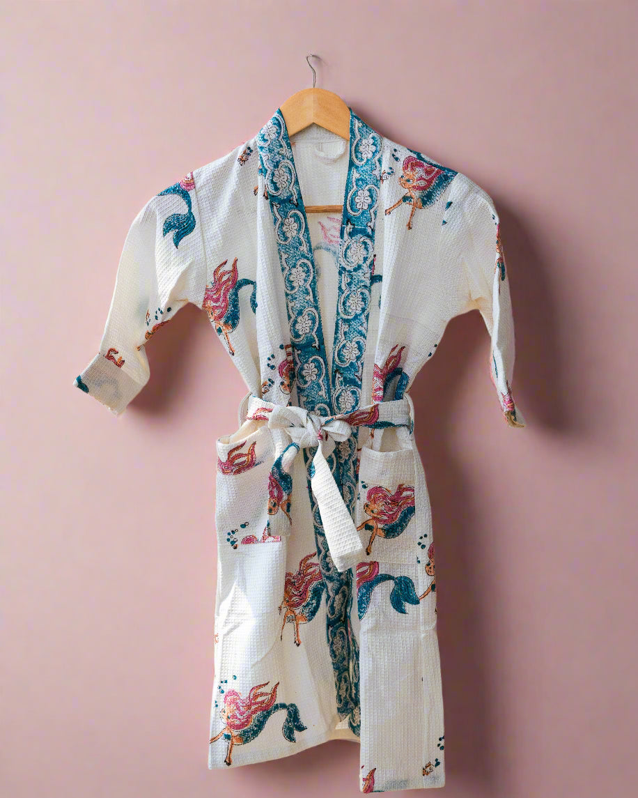 Floral patterned robe hanging on a wooden hanger against a neutral wall.