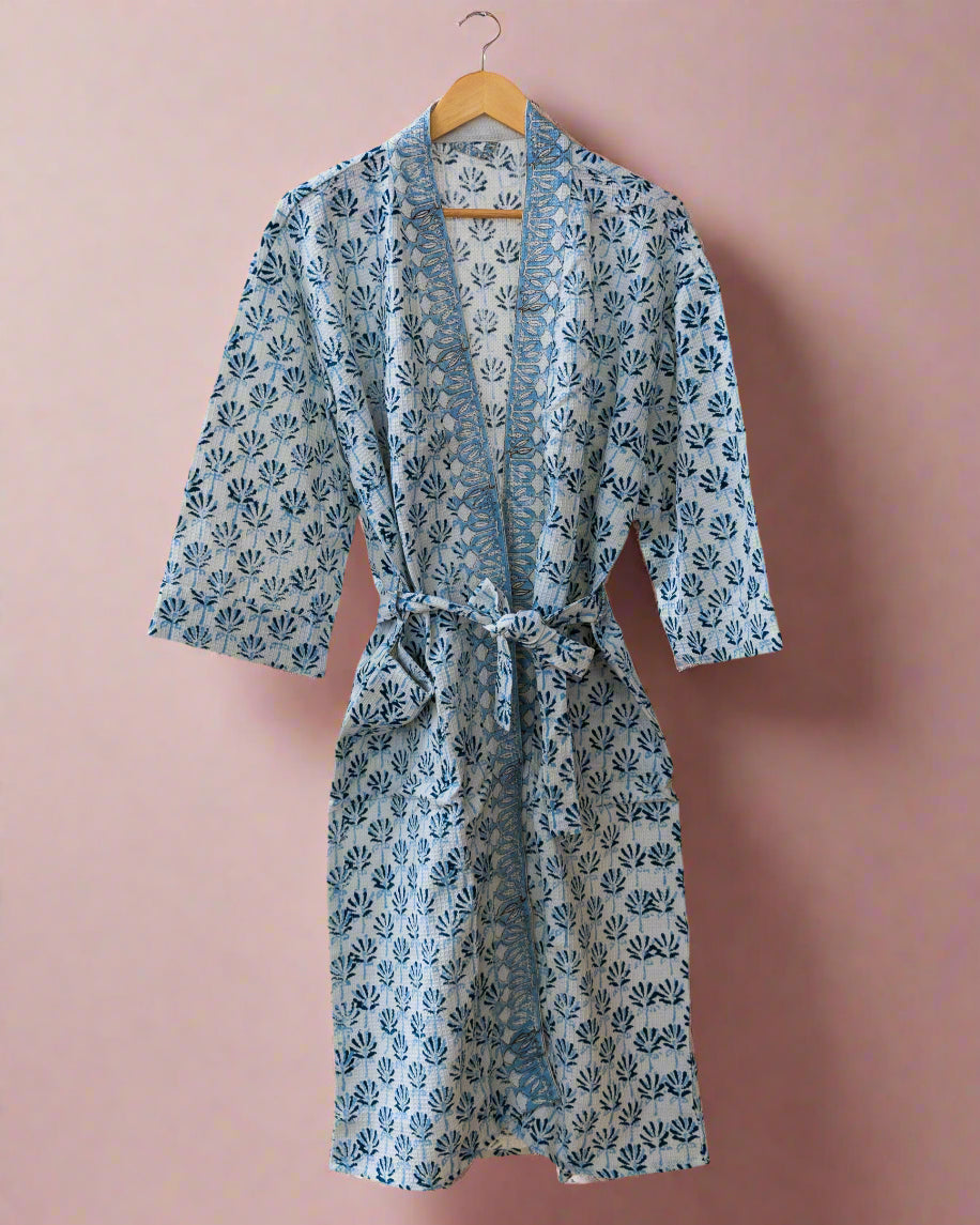 Blue floral patterned robe hanging on a wooden rack.