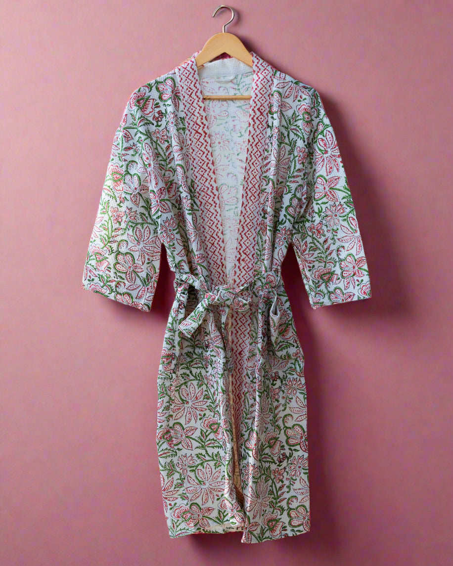 Floral patterned robe hanging on a wooden rack in a room with wooden flooring.